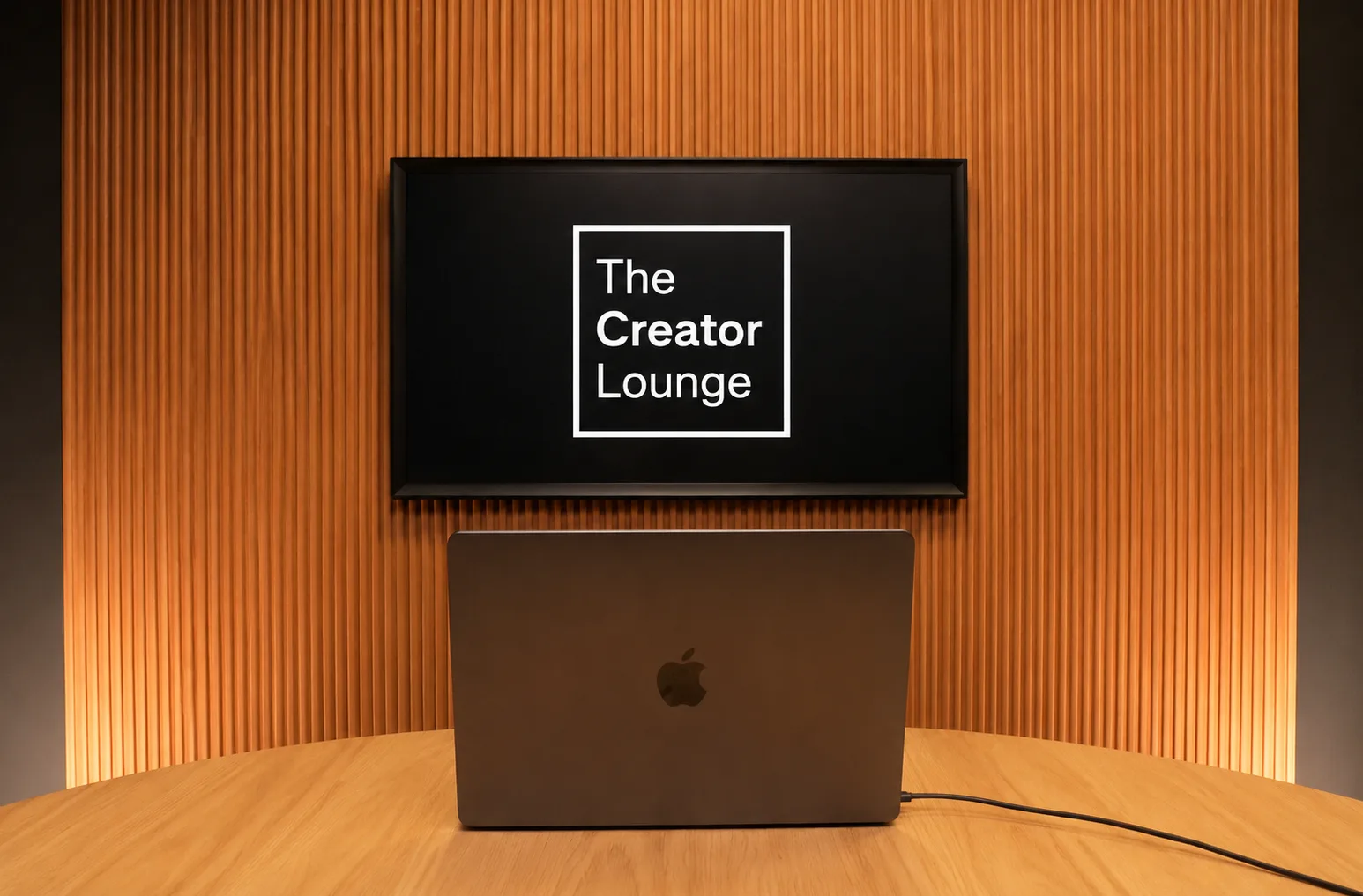 The Den backdrop with The Creator Lounge logo on screen above a laptop